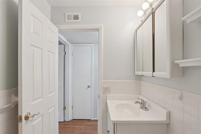 2370 Jamaican St Unit 44, Clearwater, FL 33763 - bathroom with tile walls, vanity, wainscoting, and wood finished floors