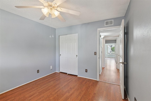2370 Jamaican St Unit 44, Clearwater, FL 33763 - unfurnished bedroom featuring a textured ceiling, wood finished floors, ceiling fan, and a closet