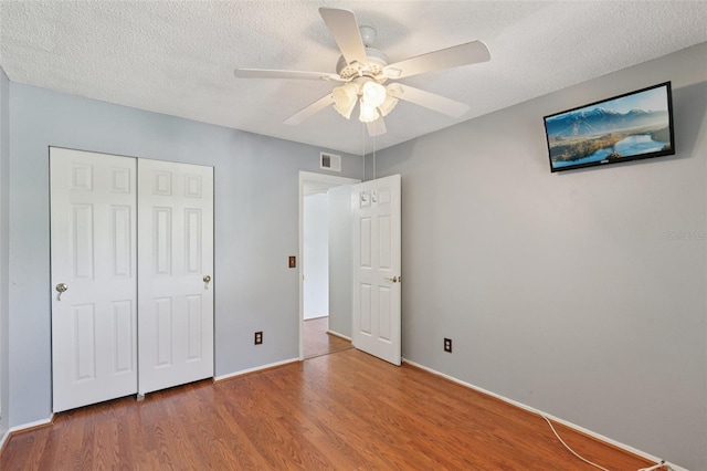 2370 Jamaican St Unit 44, Clearwater, FL 33763 - unfurnished bedroom with wood finished floors, a closet, a textured ceiling, and a ceiling fan