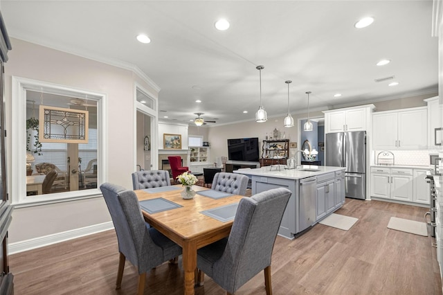 13252 SW 6th Ave, Newberry, FL 32669 - dining space with a fireplace, ceiling fan, recessed lighting, light wood-type flooring, and crown molding
