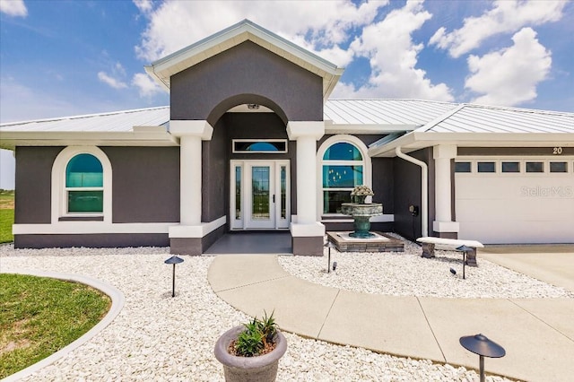 20 Bunker Ter, Rotonda West, FL 33947 - view of front of house featuring a metal roof, a garage, a standing seam roof, and stucco siding
