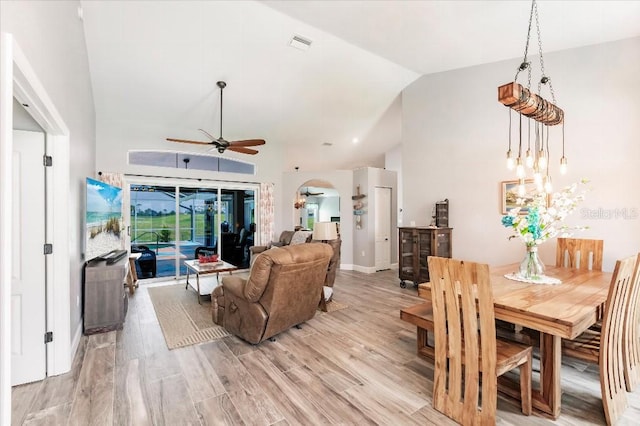 20 Bunker Ter, Rotonda West, FL 33947 - dining room with a ceiling fan, arched walkways, high vaulted ceiling, light wood finished floors, and a chandelier