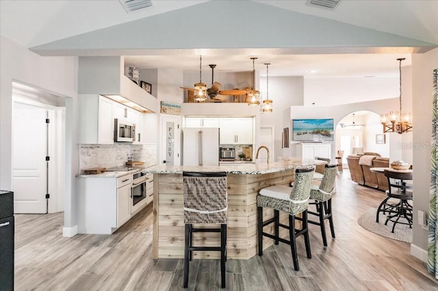 20 Bunker Ter, Rotonda West, FL 33947 - kitchen featuring freestanding refrigerator, a chandelier, high vaulted ceiling, light wood-style floors, and a kitchen breakfast bar