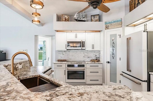 20 Bunker Ter, Rotonda West, FL 33947 - kitchen with white appliances, backsplash, light stone countertops, and white cabinets