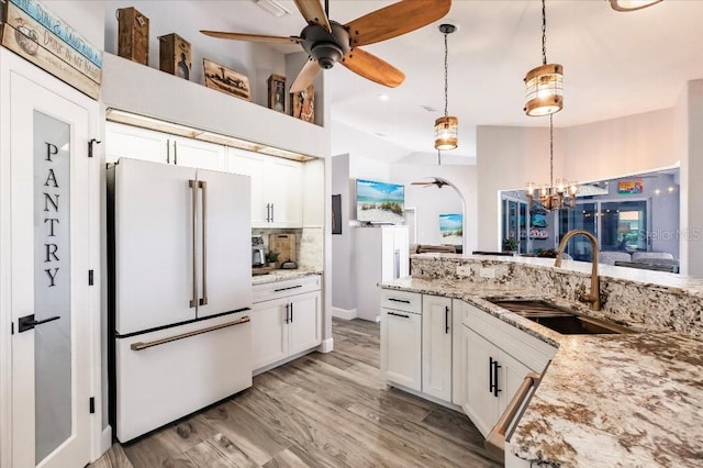 20 Bunker Ter, Rotonda West, FL 33947 - kitchen with freestanding refrigerator, a ceiling fan, tasteful backsplash, white cabinetry, and a chandelier