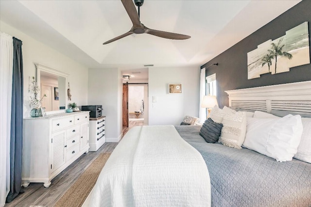 20 Bunker Ter, Rotonda West, FL 33947 - bedroom with wood finished floors, ensuite bath, a ceiling fan, and a tray ceiling
