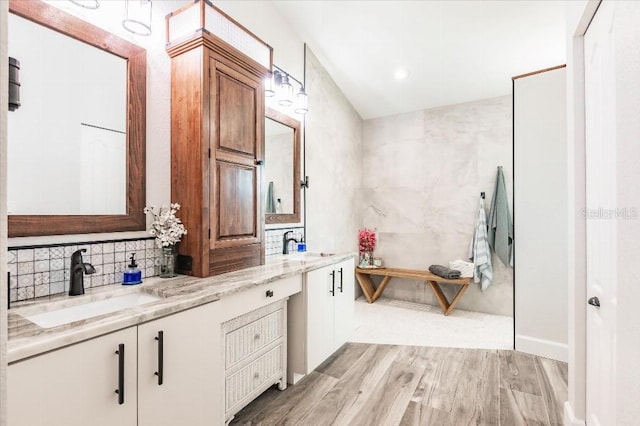 20 Bunker Ter, Rotonda West, FL 33947 - bathroom featuring double vanity, wood finished floors, backsplash, and recessed lighting