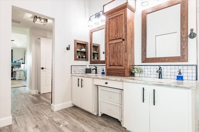 20 Bunker Ter, Rotonda West, FL 33947 - bathroom with tasteful backsplash, wood finished floors, and double vanity