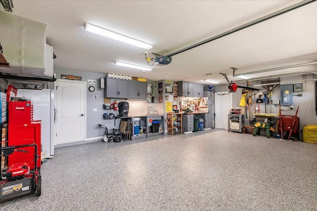 20 Bunker Ter, Rotonda West, FL 33947 - garage with a garage door opener, electric panel, and white refrigerator