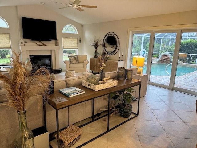 1060 Harbour Wood Dr, Punta Gorda, FL 33983 - living area featuring ceiling fan, a glass covered fireplace, light tile patterned flooring, and vaulted ceiling