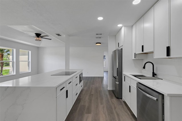 4957 N Cranberry Blvd, North Port, FL 34286 - kitchen featuring appliances with stainless steel finishes, a kitchen island, recessed lighting, wood finished floors, and white cabinetry