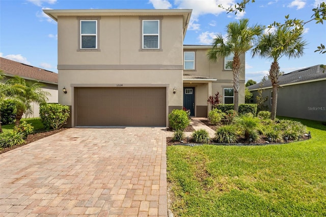 12124 Lake Blvd, Trinity, FL 34655 - view of front facade with stucco siding, decorative driveway, a garage, and a front lawn