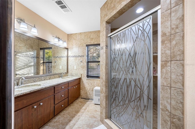 1304 N Jasmine Ave, Tarpon Springs, FL 34689 - bathroom with tile walls, double vanity, a stall shower, and tile patterned flooring