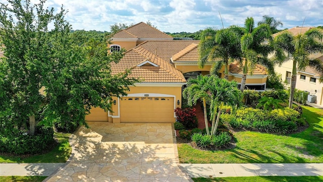 15110 Sundial Pl, Lakewood Ranch, FL 34202 - mediterranean / spanish-style home featuring stucco siding, a tiled roof, an attached garage, and driveway