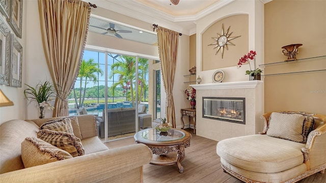 15110 Sundial Pl, Lakewood Ranch, FL 34202 - living area featuring a ceiling fan, wood finished floors, crown molding, and a fireplace
