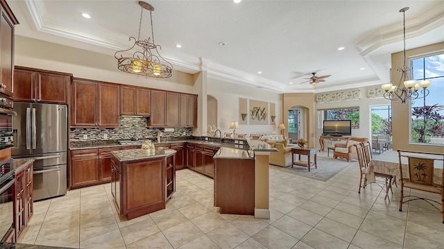 15110 Sundial Pl, Lakewood Ranch, FL 34202 - kitchen featuring a raised ceiling, arched walkways, stainless steel appliances, ceiling fan, and a kitchen island