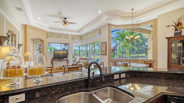 15110 Sundial Pl, Lakewood Ranch, FL 34202 - kitchen with ceiling fan, a raised ceiling, dark stone counters, crown molding, and open floor plan