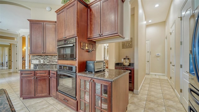 15110 Sundial Pl, Lakewood Ranch, FL 34202 - kitchen with backsplash, dark stone counters, recessed lighting, a peninsula, and glass insert cabinets