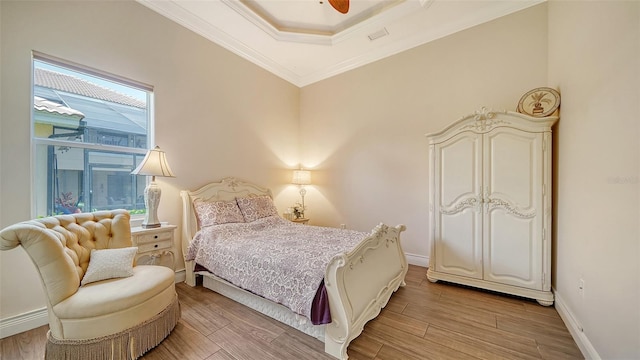 15110 Sundial Pl, Lakewood Ranch, FL 34202 - bedroom with light wood-style flooring, ornamental molding, a tray ceiling, and a ceiling fan