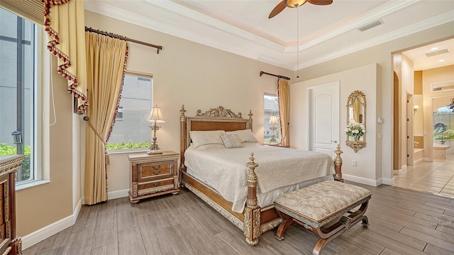 15110 Sundial Pl, Lakewood Ranch, FL 34202 - bedroom featuring wood finished floors, crown molding, ensuite bathroom, ceiling fan, and a tray ceiling