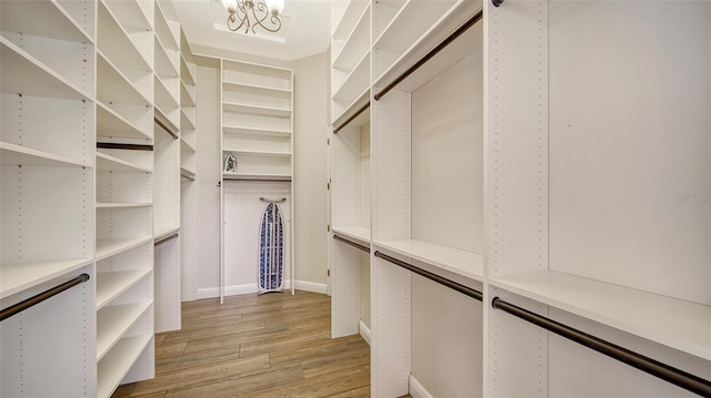 15110 Sundial Pl, Lakewood Ranch, FL 34202 - walk in closet featuring light wood finished floors and a chandelier