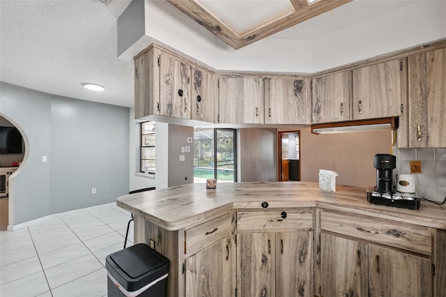 1116 Dagmar Ave, Spring Hill, FL 34606 - kitchen with light countertops, a peninsula, a textured ceiling, and light tile patterned flooring