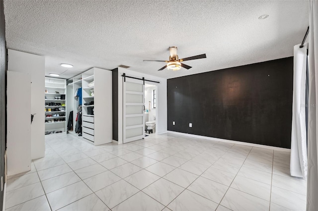 1116 Dagmar Ave, Spring Hill, FL 34606 - empty room featuring a barn door, ceiling fan, a textured ceiling, light tile patterned floors, and built in features