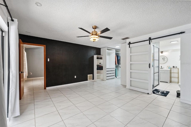 1116 Dagmar Ave, Spring Hill, FL 34606 - unfurnished room with a barn door, ceiling fan, and a textured ceiling