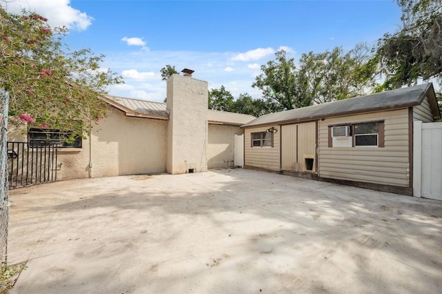 1116 Dagmar Ave, Spring Hill, FL 34606 - rear view of house featuring a chimney, a patio, a standing seam roof, and a metal roof