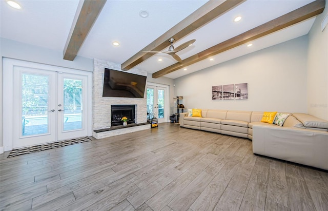 1120 Lancer Ln, Tarpon Springs, FL 34689 - living area featuring french doors, wood finished floors, a ceiling fan, and a stone fireplace