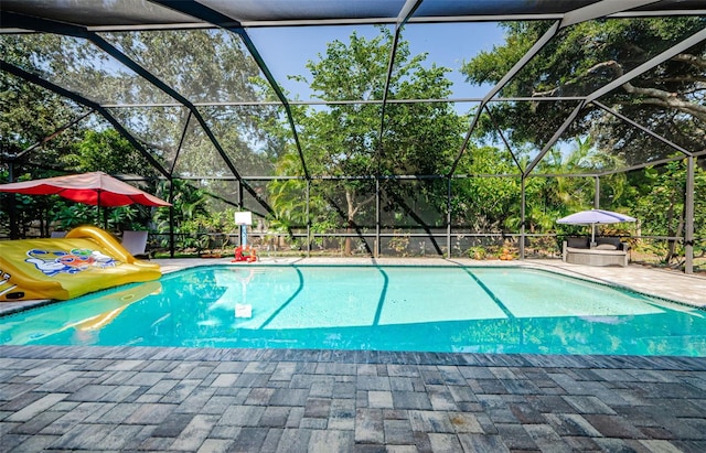 1120 Lancer Ln, Tarpon Springs, FL 34689 - swimming pool featuring a patio area, glass enclosure, and view of scattered trees