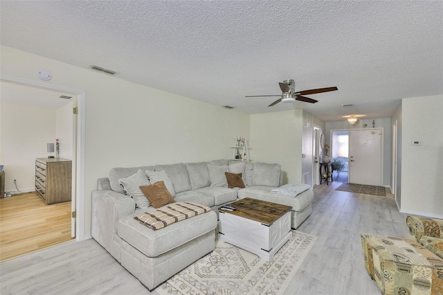 2510 Locksley St Unit 2510, Sun City Center, FL 33573 - living room with light wood-style floors, a ceiling fan, and a textured ceiling