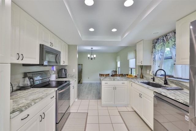 2510 Locksley St Unit 2510, Sun City Center, FL 33573 - kitchen with stainless steel range with electric stovetop, black dishwasher, a peninsula, white cabinets, and a raised ceiling
