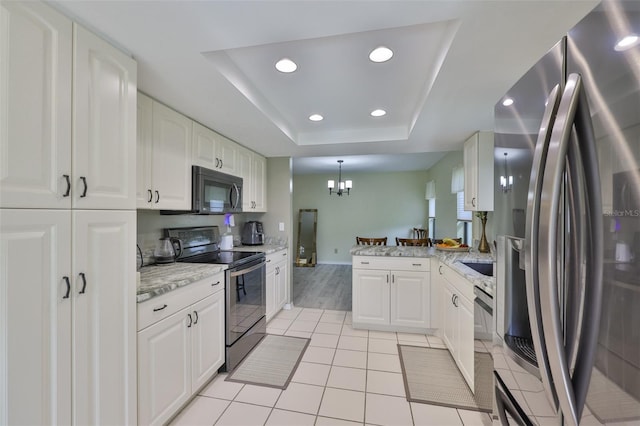 2510 Locksley St Unit 2510, Sun City Center, FL 33573 - kitchen with appliances with stainless steel finishes, white cabinetry, a raised ceiling, a chandelier, and recessed lighting