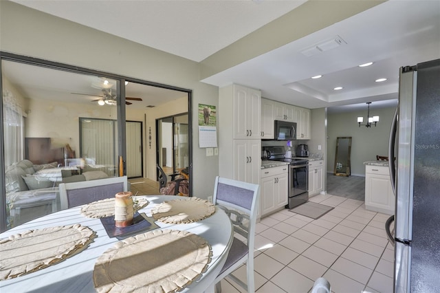 2510 Locksley St Unit 2510, Sun City Center, FL 33573 - dining room featuring light tile patterned floors, ceiling fan, a chandelier, and a tray ceiling