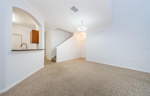 2148 Chianti Pl Unit 1310, Palm Harbor, FL 34683 - unfurnished living room with light carpet, crown molding, stairs, arched walkways, and a chandelier