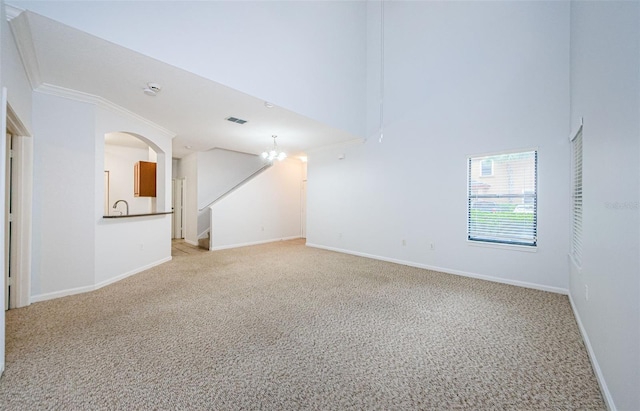 2148 Chianti Pl Unit 1310, Palm Harbor, FL 34683 - unfurnished room with light colored carpet, stairway, a towering ceiling, and ornamental molding