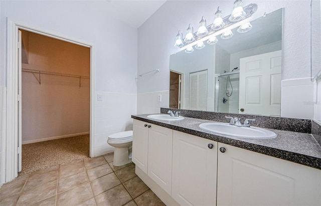 2148 Chianti Pl Unit 1310, Palm Harbor, FL 34683 - bathroom with a shower stall, double vanity, a walk in closet, and tile patterned floors