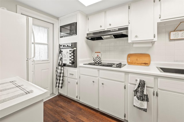 500 Glennes Ln Unit 206, Dunedin, FL 34698 - kitchen with black appliances, under cabinet range hood, light countertops, decorative backsplash, and dark wood finished floors