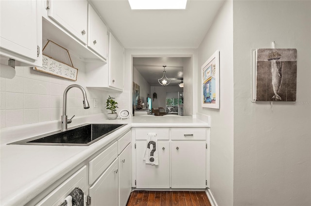 500 Glennes Ln Unit 206, Dunedin, FL 34698 - kitchen featuring tasteful backsplash, dark wood-style flooring, light countertops, and white cabinets