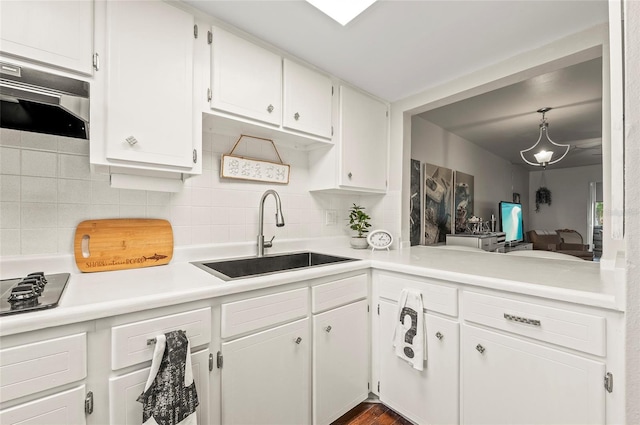 500 Glennes Ln Unit 206, Dunedin, FL 34698 - kitchen featuring extractor fan, tasteful backsplash, white cabinetry, light countertops, and black gas cooktop