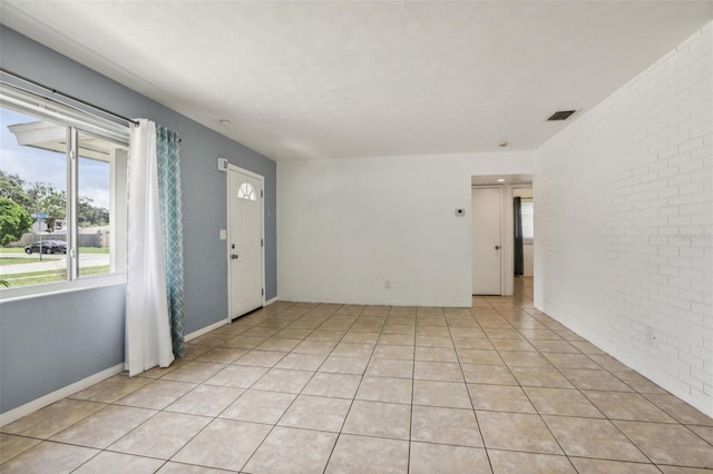992 20th St SW, Largo, FL 33770 - empty room featuring brick wall and light tile patterned flooring