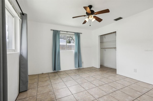 992 20th St SW, Largo, FL 33770 - unfurnished bedroom with light tile patterned flooring, a closet, and a ceiling fan