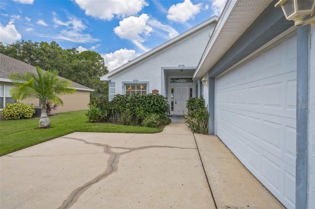 1754 Turtle Rock Dr, Lakeland, FL 33803 - view of exterior entry with stucco siding, a lawn, a patio, and concrete driveway