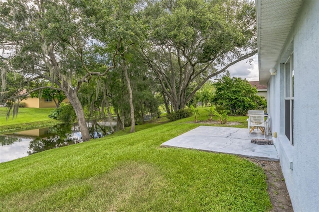 1754 Turtle Rock Dr, Lakeland, FL 33803 - view of green lawn featuring a patio area and a water view