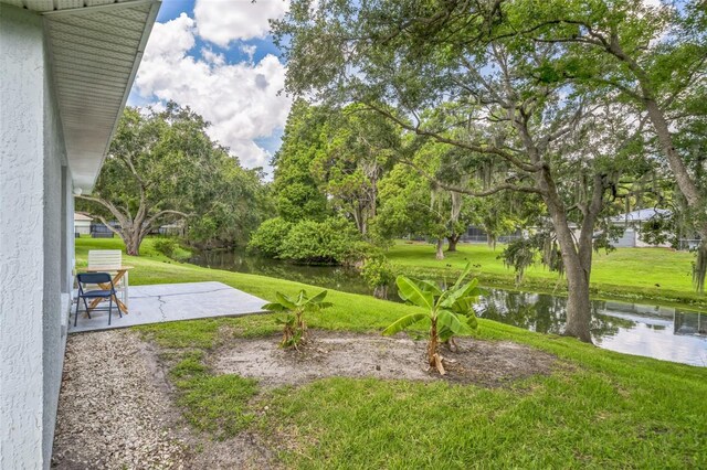 1754 Turtle Rock Dr, Lakeland, FL 33803 - view of green lawn featuring a patio and a water view