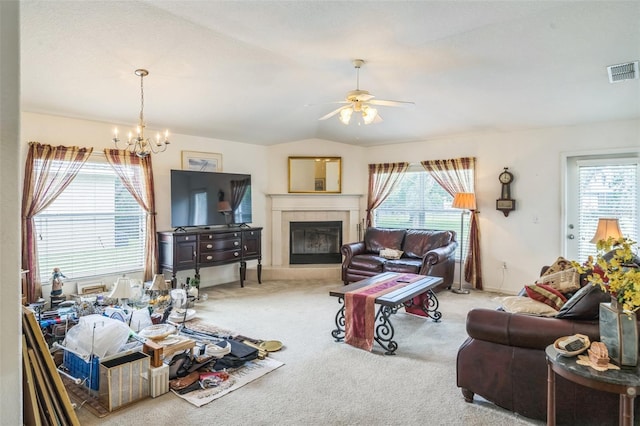 1754 Turtle Rock Dr, Lakeland, FL 33803 - carpeted living area featuring plenty of natural light, a chandelier, a tiled fireplace, a ceiling fan, and lofted ceiling