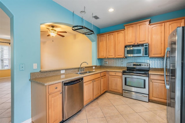 14167 Stilton St, Tampa, FL 33626 - kitchen with stainless steel appliances, light tile patterned floors, ceiling fan, arched walkways, and backsplash
