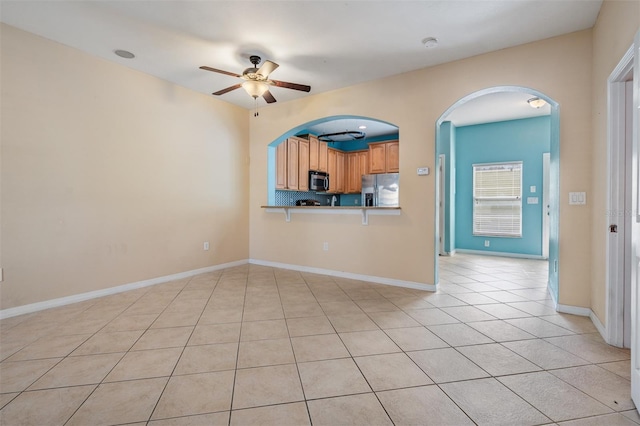 14167 Stilton St, Tampa, FL 33626 - unfurnished living room with ceiling fan, light tile patterned floors, and arched walkways