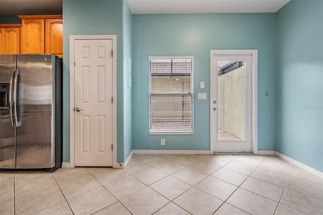 14167 Stilton St, Tampa, FL 33626 - kitchen with stainless steel fridge with ice dispenser, light tile patterned floors, and brown cabinets